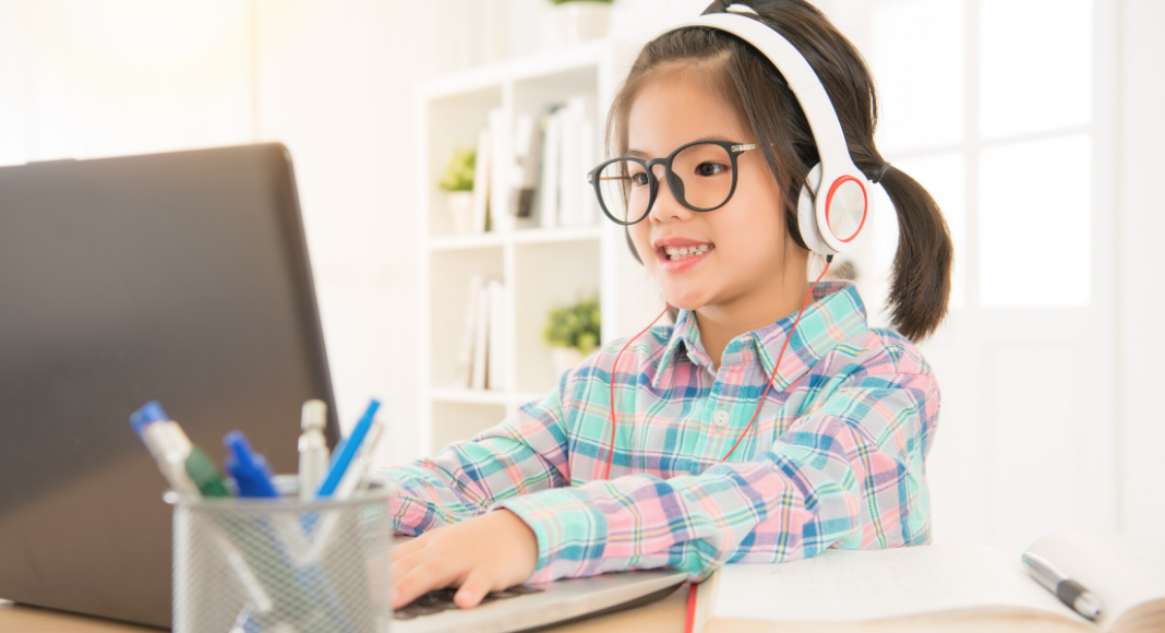 online learning resources for kids - girl at computer with headphones