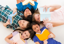 tweens lying in circle with heads together looking at books
