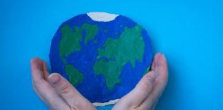Two hands holding a planet Earth.