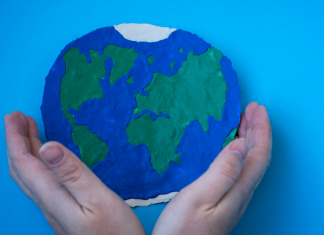 Two hands holding a planet Earth.