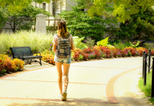 young woman walking away with a backpack