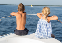 two kids on bow of small boat