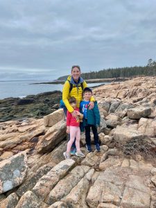 Mom and two kids on shoreline rocks in acadia national park