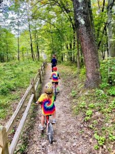 two kids on bikes follow dad on a bike trail