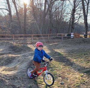 child dressed for winter at a pump track