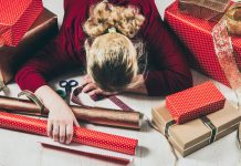 overwhelmed woman among wrapping paper