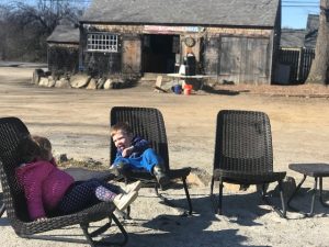 kids sit outside farm store 